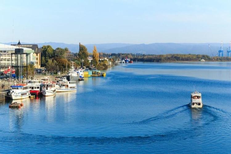 Embarcaciones en un río junto a una zona urbana
