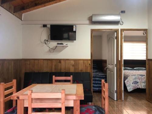 Comedor, zona de estar y accesos a dormitorios de una cabaña