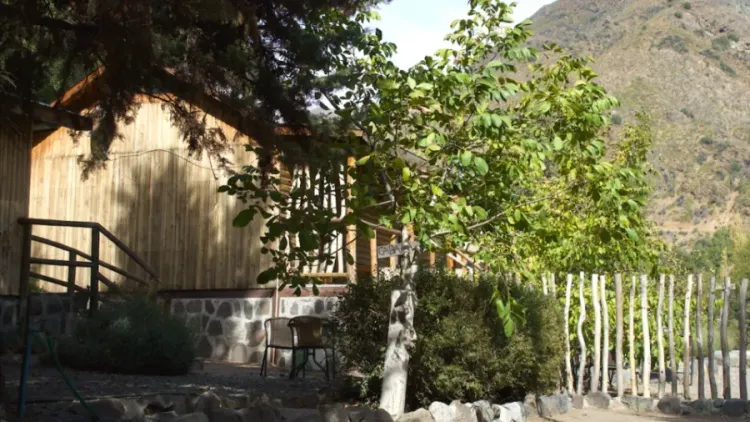 Construcción de madera entre árboles con ladera al fondo