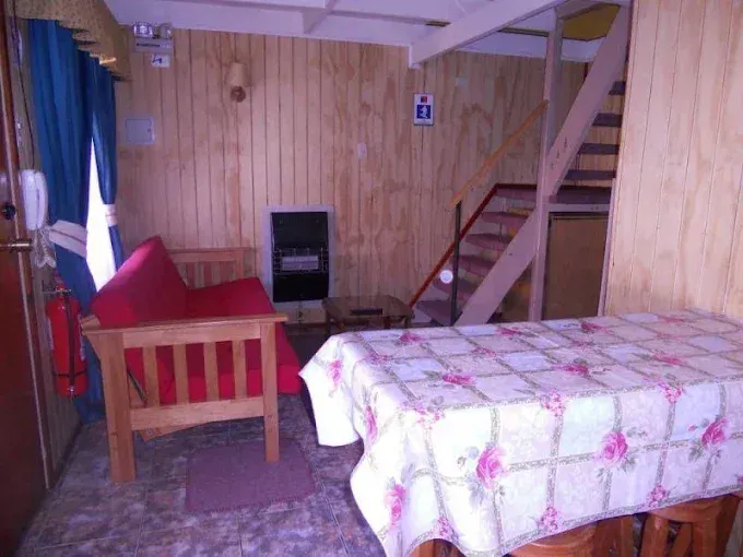 Interior con mesa de comedor, sofá, calefactor y escalera