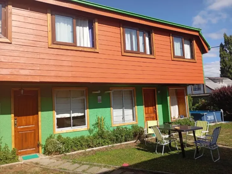 Fachada de Cabañas Emanuel con patio, mesa y sillas