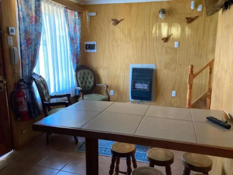 Comedor interior con mesa amplia, calefactor y escalera