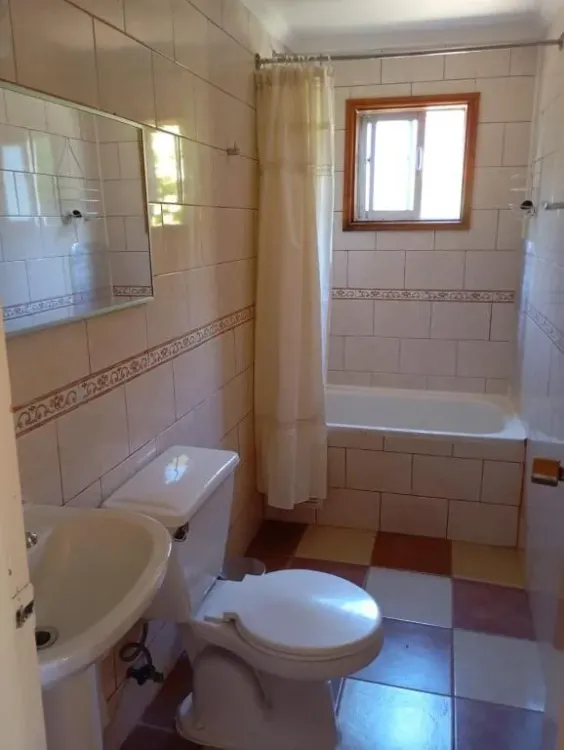 Baño revestido con lavamanos, inodoro y tina