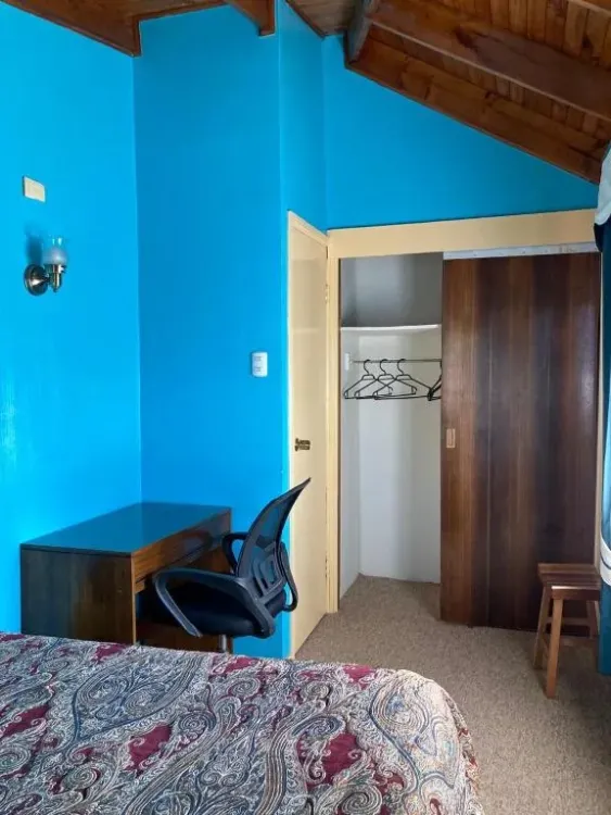 Dormitorio con cama, escritorio y clóset abierto